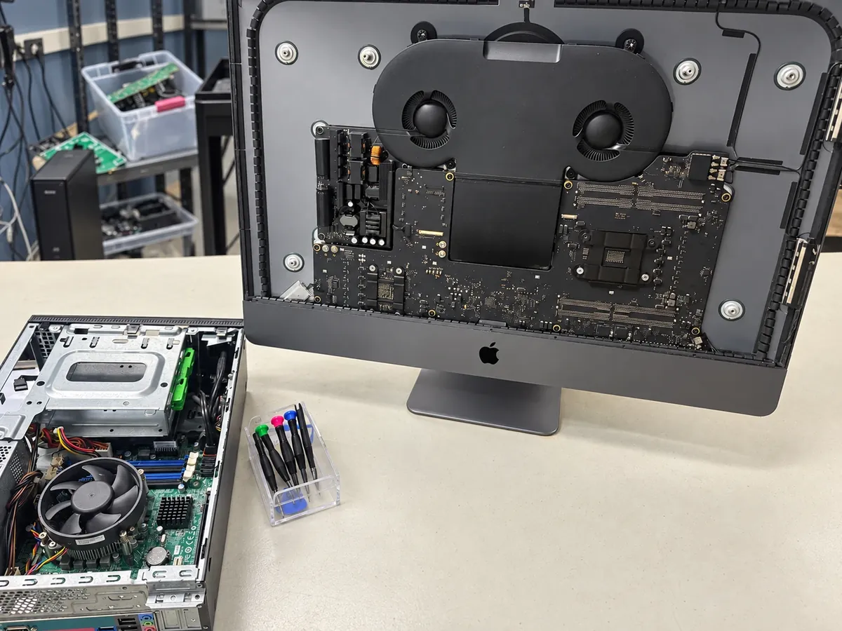 iMac Pro opened for repair next to a desktop PC on a Budget Repair workbench