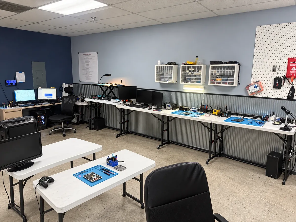 Budget Repair repair room with workbenches, computer monitors, and anti-static repair mats