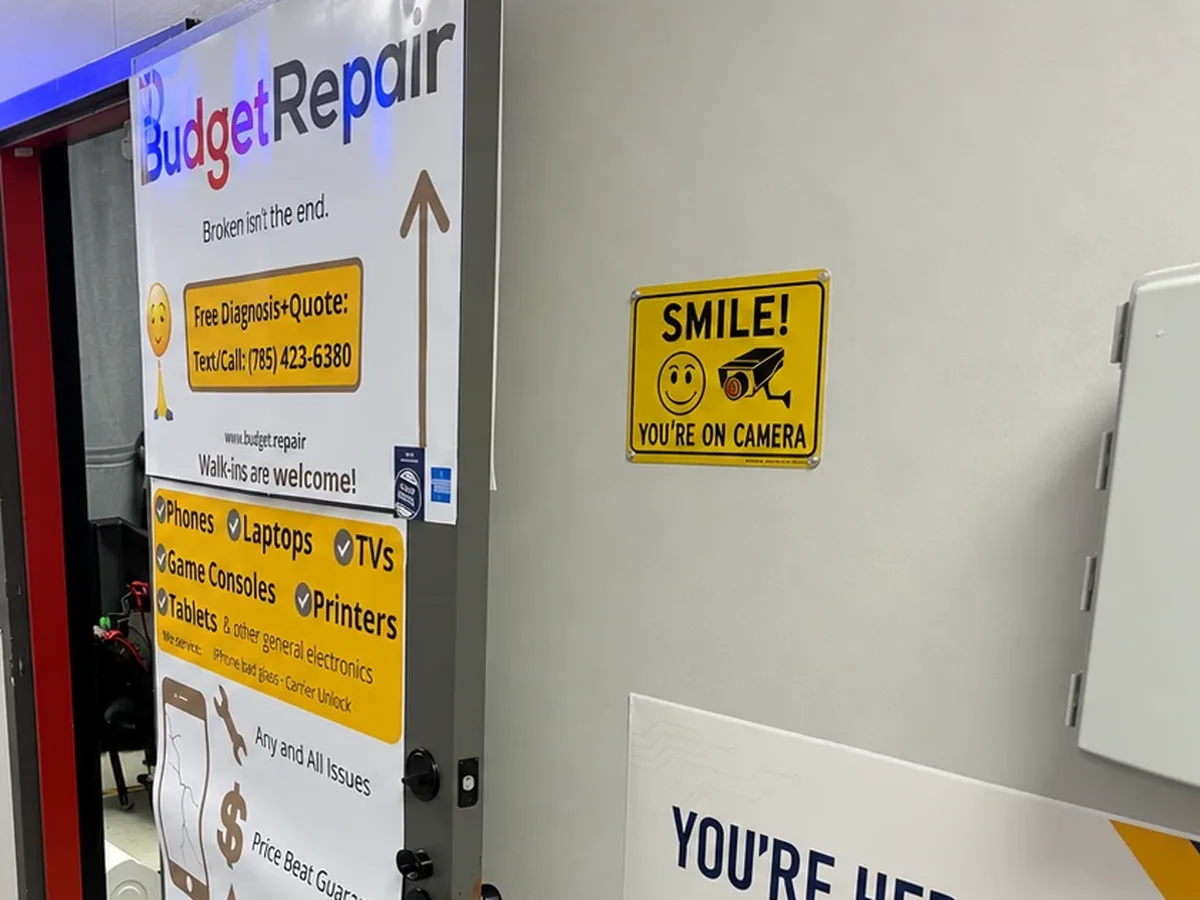 Budget Repair Suite B4 door with signs listing phone, laptop, TV, game console, and tablet repair